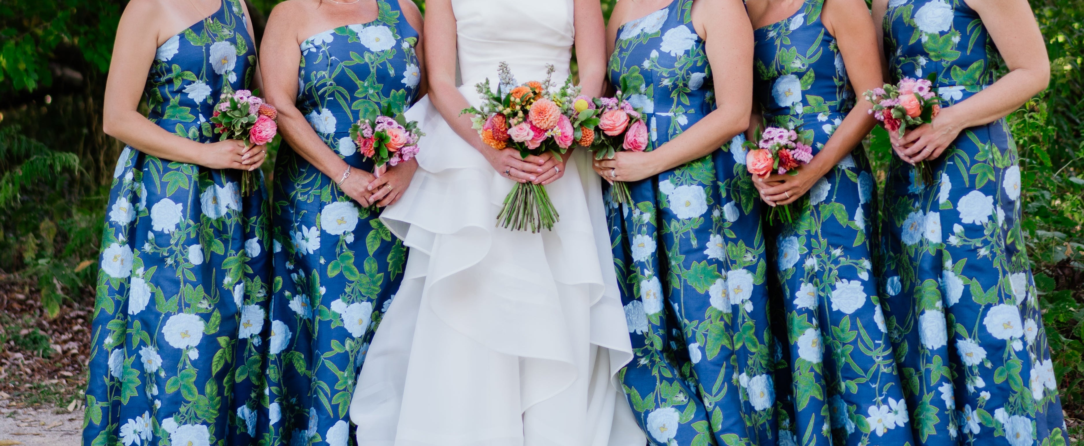 Bride with bridesmaids in floral dresses outdoors